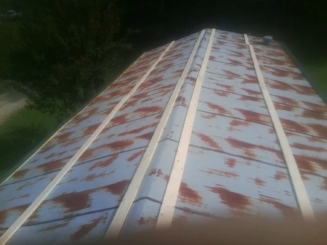Rusted metal roof panels with new wood purlins before replacement — Storm Damage Roof Repair in Strawberry Plains by Roofing Brothers