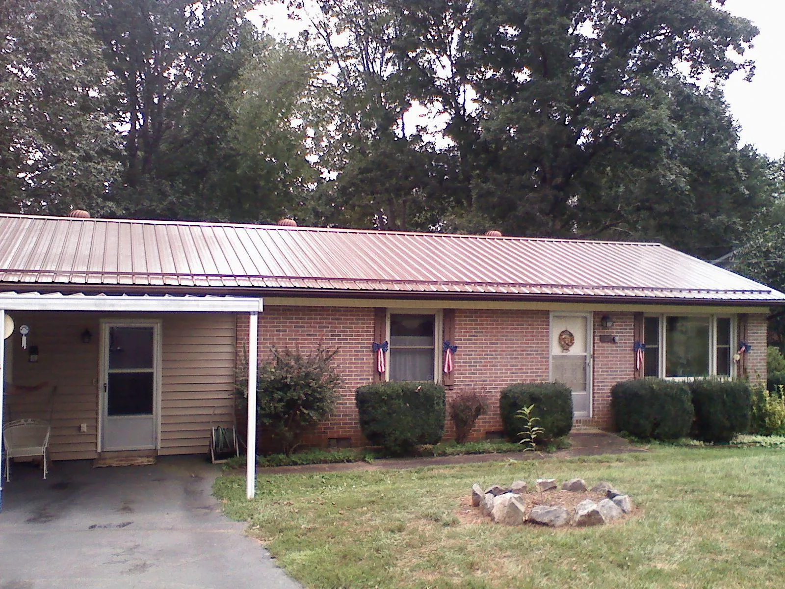Bronze metal roof and carport on a brick ranch home — Roof Repair work by our crew in Strawberry Plains