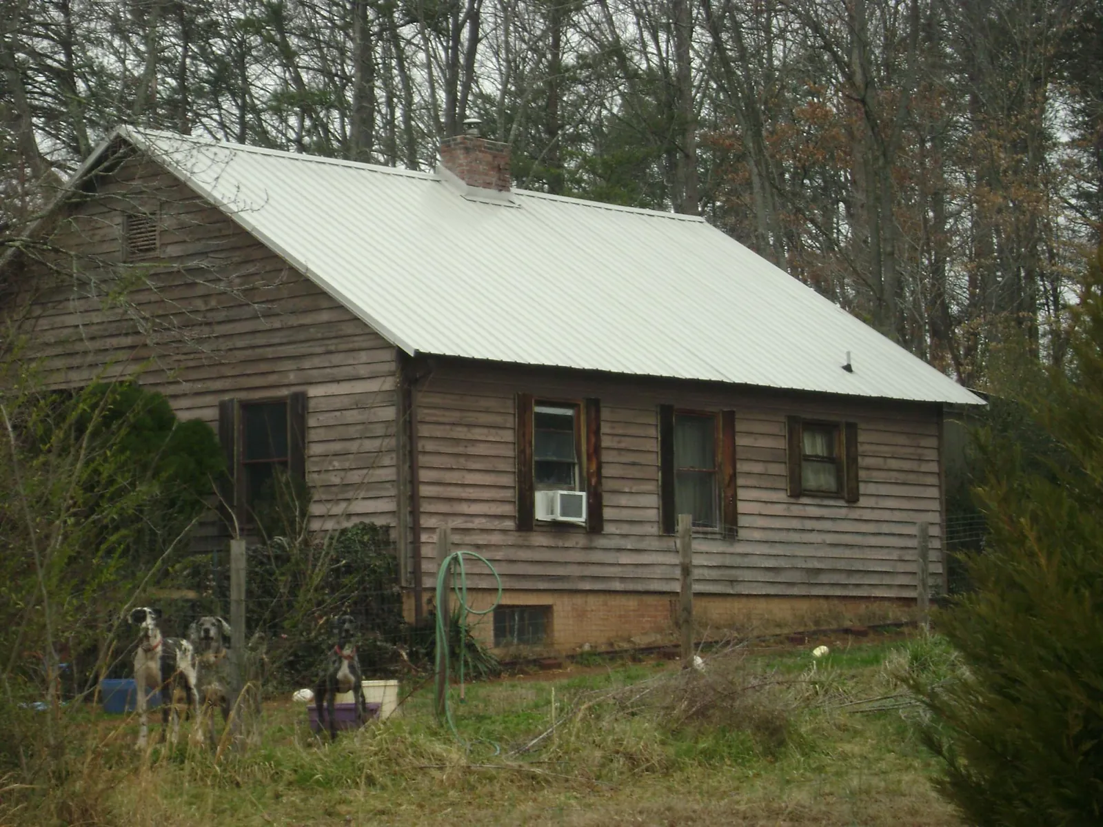 White metal roof on an old wood sided farmhouse, from a Metal Roof Installation job in Strawberry Plains